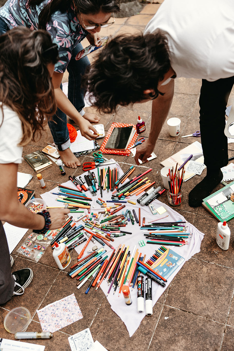 Grupo de personas trabajando con papel y materiales en el suelo